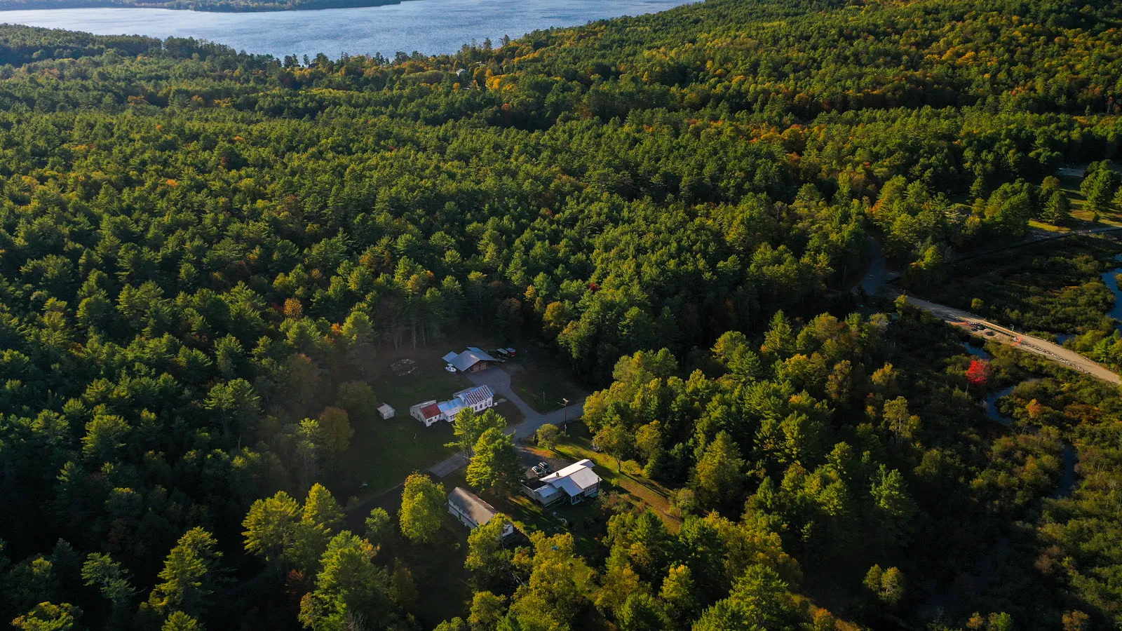 Aerial view of Park Mountain Campground nestled in the Adirondack forest with Schroon Lake visible in the background