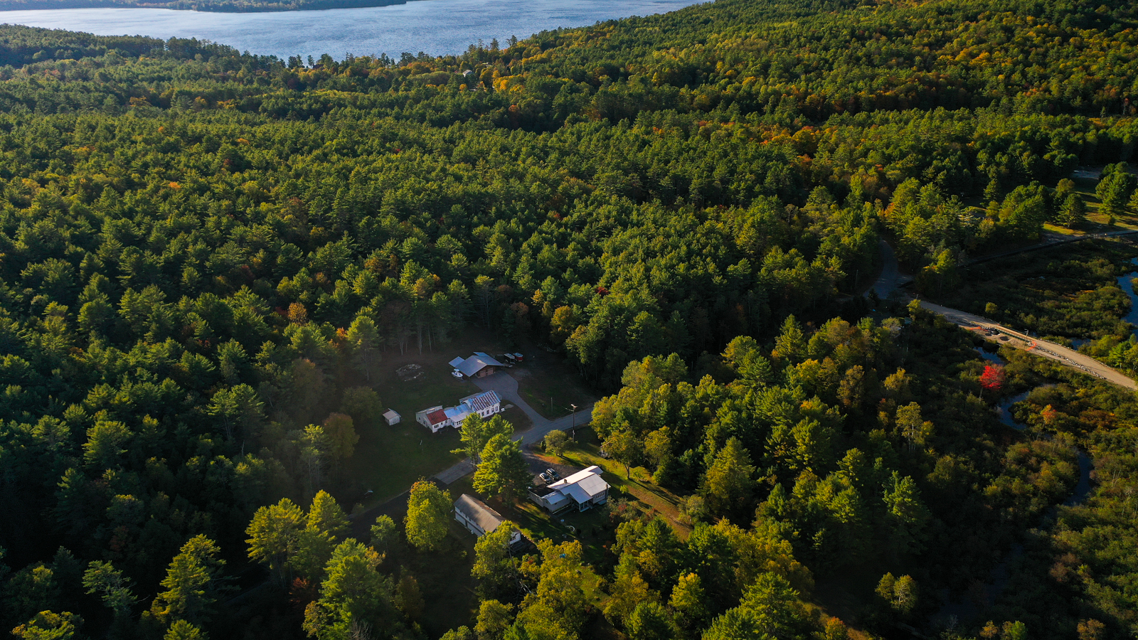 Aerial view of Park Mountain Campground nestled in the Adirondack forest with Schroon Lake visible in the background